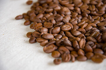Heap of Aromatic Roasted Coffee Beans on a Textured White Background
