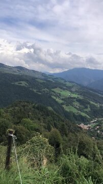 View from a Stone Mountain House on the Val del Riso Valley, in the Italian Alps, During a Cloudy Summer Day