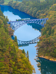 Fototapeta premium 紅葉の萌える山々と只見線第一橋梁を渡る機関車