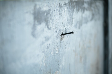 Closeup view of rusty nails stuck in a wall of concrete. The rustic Nail embedded in weathered concrete surface with minimalist details.