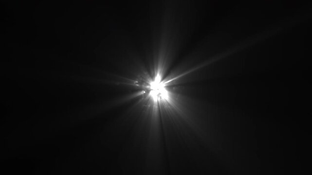 White Glowing Energy Orb Emitting Moving Light Rays From Central Point from Darkness. Abstract Energy Flares Shining on Black Background. UFO Alien Style Effect.