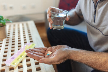 Container, senior man and organise pills tablet, health medication or pharmaceutical prescription. Home sofa, medical supplement drugs and Caucasian elderly person set daily healthcare medicine.