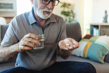 Old man, hands and tablet container in home, arthritis treatment and water for antibiotics or...