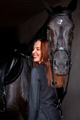 Woman near horse. Rider in a black uniform