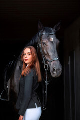 Woman near horse. Rider in a black uniform