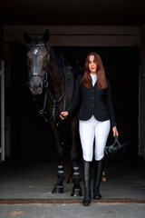 Woman near horse. Rider in a black uniform