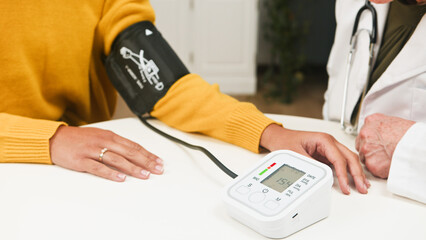 Patient Getting Blood Pressure Checked By Doctor Using Digital Monitor In Clinic Setting