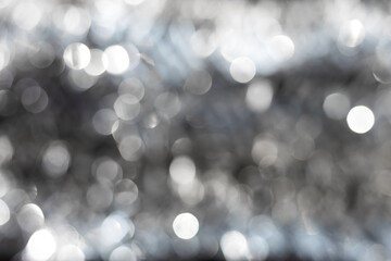 Silver and white bokeh background with soft blurred circles of light creating sparkling festive texture. Elegant abstract ideal for luxury design, winter holiday themes, modern minimalist compositions
