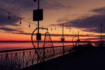 Beautiful lake pier scenery during autumn sunrise with dark silhouettes. Morning in Riga, Latvia.