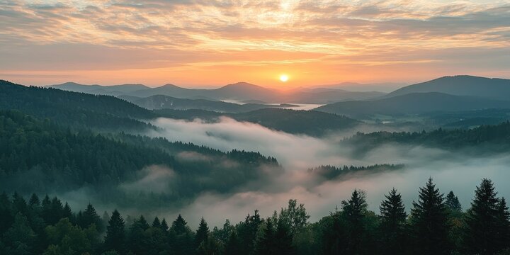 A breathtaking sunrise over a dense forest with rolling hills and misty valleys, featuring a vibrant orange sun and a cloudy sky.