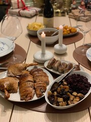Traditional Danish Christmas Dinner with Roast Duck and Red Cabbage; roast duck, caramelized potatoes, red cabbage, and sausages, served with rich gravy and candlelight
