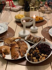 Traditional Danish Christmas Dinner with Roast Duck and Red Cabbage; roast duck, caramelized potatoes, red cabbage, and sausages, served with rich gravy and candlelight