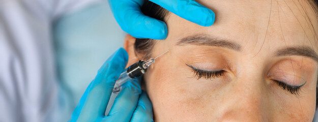 Cosmetic treatment and closeup hands of a cosmetologist making facial skin