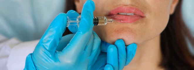 Young caucasian woman getting botox cosmetic injection in lips