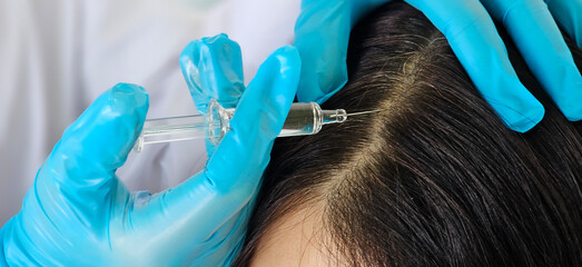 Beauty clinic cosmetician gloves making injection with syringe in black hair roots