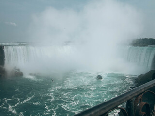 A close-up view of Niagara Falls on a foggy day with mist covering the waterfall