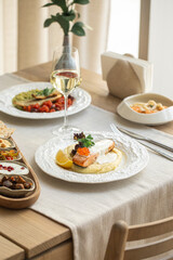 Grilled salmon served with creamy mashed potatoes, lemon wedge and fish roe on a white plate