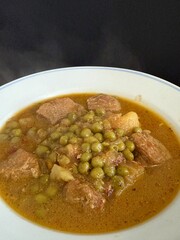 Braised potatoes with green peas and meat.