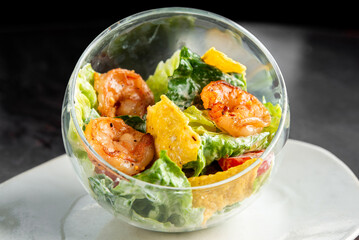 A delicious Caesar salad with grilled shrimp, romaine lettuce, parmesan cheese, and croutons served...