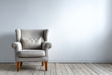 Upholstered armchair with cushion rests against a plain light colored wall above wooden flooring