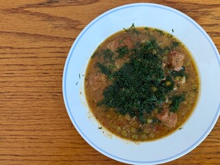 Braised potatoes with green peas, meat, and fresh dill. Delicious home cooking.