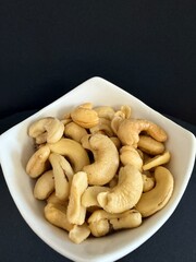 Close-up of dried cashews in a white bowl. Healthy, natural food.