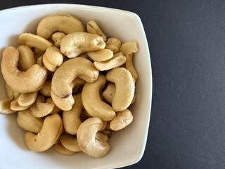 Close-up of dried cashews in a white bowl. Healthy, natural food.