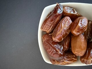 Close-up of dried dates in a white bowl. Healthy, natural food.