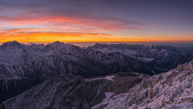 Twilight casting glow on icy mountain summits. Scenic perspective from the highlands to a towering peak in the region.