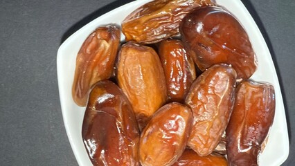 Close-up of dried dates in a white bowl. Healthy, natural food.