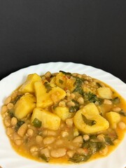 Stew with potatoes, white beans, tomatoes, and celery. Delicious home cooking.