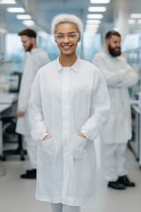 Obraz premium Female african young scientist in laboratory with colleagues