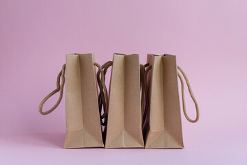 Paper shopping bags with handles on a pink background. Layout for design