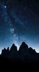 Silhouette of jagged mountain peaks against a starry night sky