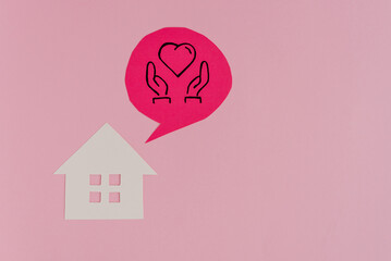 A house with thoughts of love, care, and happiness, decorated with hearts on a pink background. The...