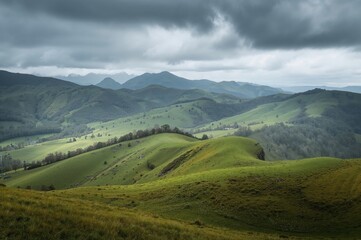 Obraz premium Undulating hills and layered landscapes extend far into the distance. Towering verdant mountains rise beneath a somber sky.