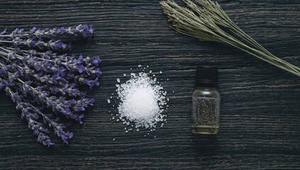 Fototapeta premium Lavender blossoms, essential oil, and bath salts arranged on a dark wooden surface for a natural spa experience