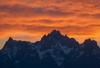 Mountain Peaks Silhouetted Against a Fiery Orange Sunset Sky