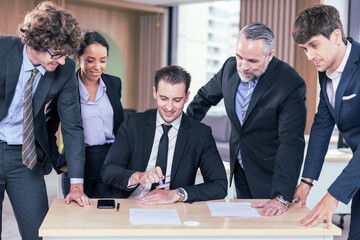 Diverse Team Working Together in Modern Co-Working Space. Casual meeting of smiling diverse business team analyzing financial data. Multiethnic business people working together in the office. 