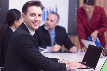 Diverse Team Working Together in Modern Co-Working Space. Casual meeting of smiling diverse business team analyzing financial data. Multiethnic business people working together in the office. 