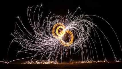 Artistic night shot glowing sparks form figure 8 against black background