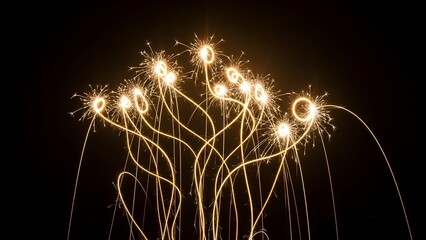Illuminated sparkler trails against a black background, forming a unique abstract pattern