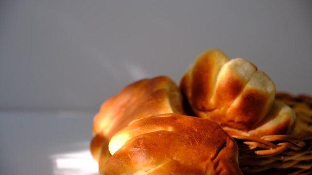 Fresh Kaiser rolls stacked on a store shelf. Group of classic bread rolls on display. Soft bread rolls in wicker basket. Bakery section with a pile of golden brown buns. For bakery product marketing