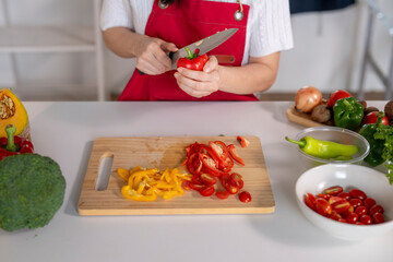 Woman cooking healthy meal preparing fresh vegetables