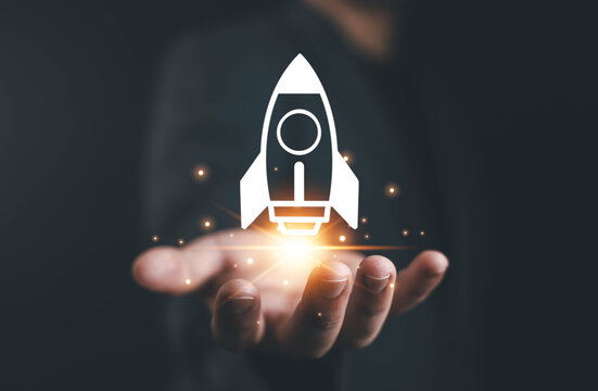 Businessman holding digital rocket icon, symbolizing startup growth, innovation, business development, success, and new technology modern digital concept connected network lines with business icons,