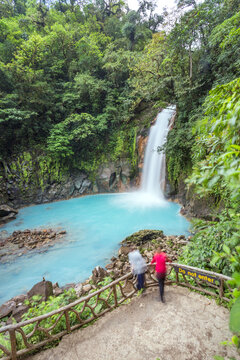 Tourist couple looking at Rio Celeste waterfall, Costa Rica
