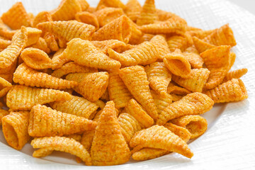 Corn cone snack chips on a white plate.
