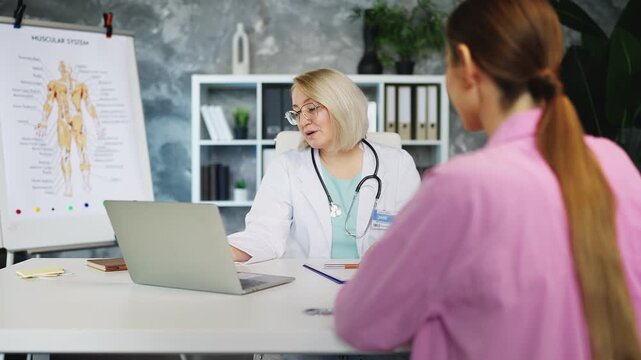 Friendly woman doctor prescribing pills to female patient during medical check