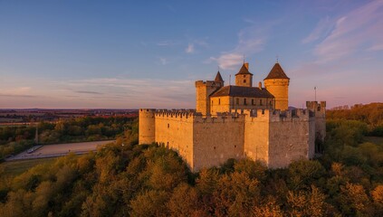 Aerial perspective of a scenic autumn landscape featuring a medieval fortress on a rocky ledge during dusk, erosion risk