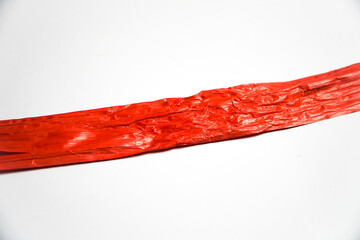 Red rope made from plastic called rafia rope string isolated on a white background.